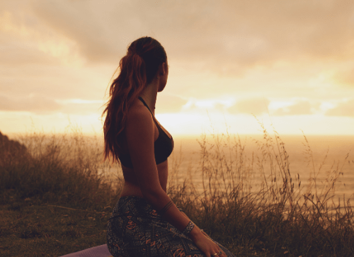 Person sitting quietly at sunset