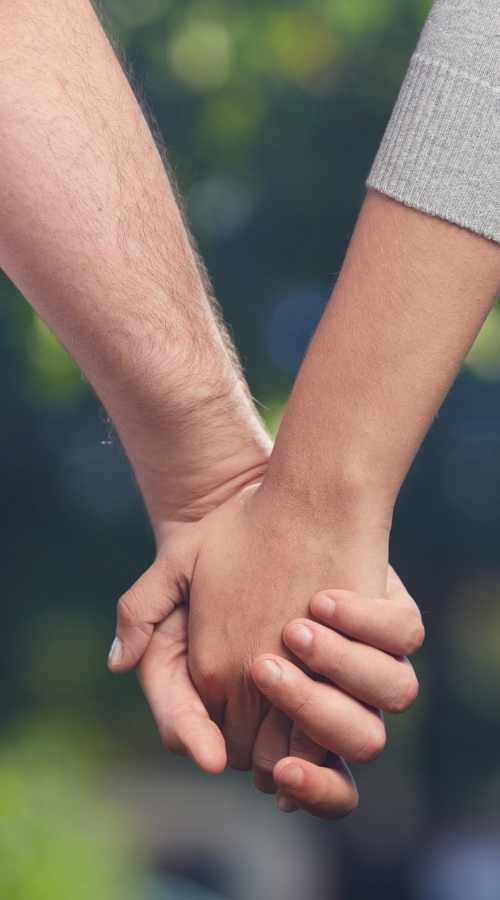 Partners holding hands in a supportive moment