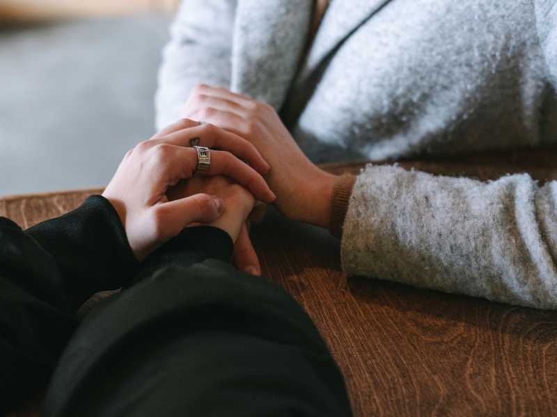 Partners holding hands during a supportive moment