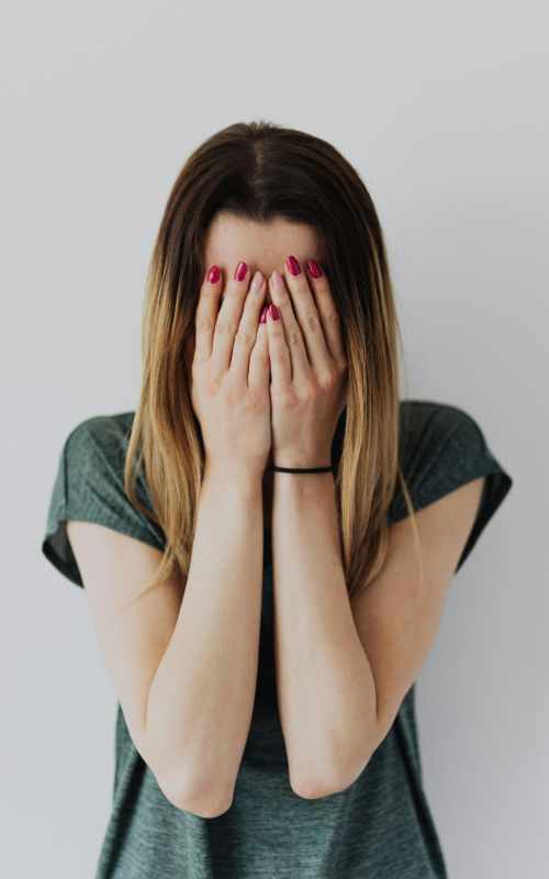 Person covering their face during emotional overwhelm
